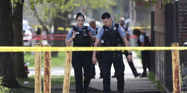 Two Chicago police officers walking on the sidewalk.