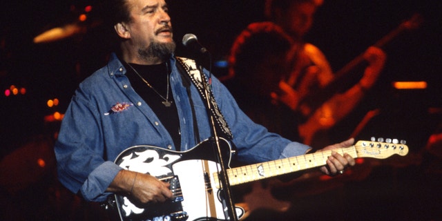 Waylon Jennings holding a guitar