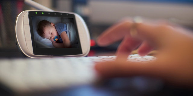 parent watches child on baby monitor