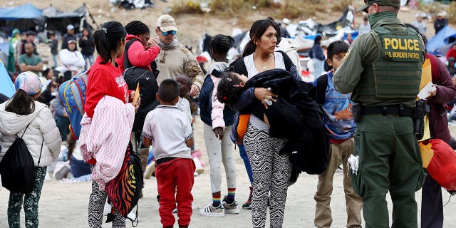 Border patrol agent speaks with migrant at border