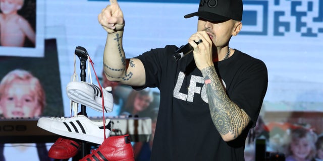 Brad Fischetti speaks into a microphone during a concert.