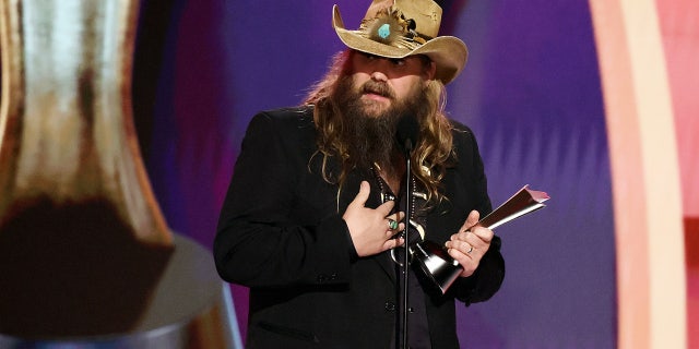 Chris Stapleton wears brown leather hat and black blazer to accept entertainer of the year award at acms