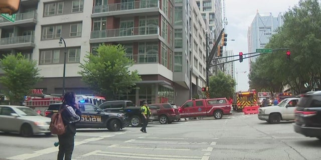 People stand near where a crane collapsed in downtown Atlanta