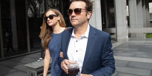 Danny Masterson holds a cup of coffee while walking into courthouse with wife Bijou Phillips