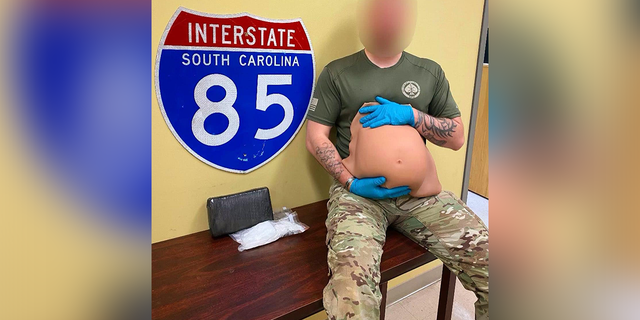 Løjtnant holder en falsk gravid mave