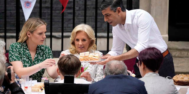 First Lady of the United States of America, Dr. Jill Biden, (C) and granddaughter Finnegan Biden (L) share cake with Prime Minister Rishi Sunak during a lunch at Downing Street