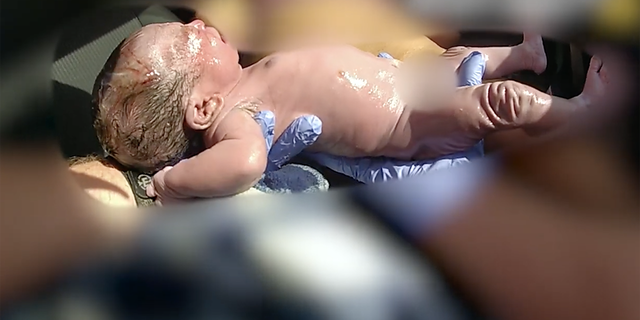 deputy holding newborn baby