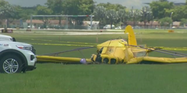 Um veículo de segurança do aeroporto está estacionado ao lado do avião que caiu