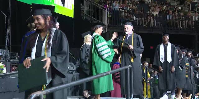 Sam Kaplan walking across stage