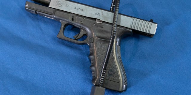Displayed is a Glock 17 pistol fitted a with a cable style gun lock in Philadelphia, Wednesday, May 10, 2023.