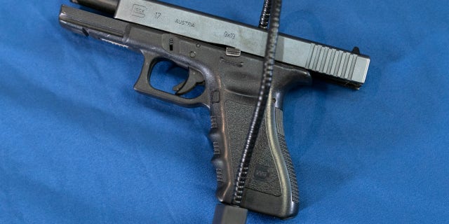 Displayed is a Glock 17 pistol fitted a with a cable style gun lock in Philadelphia, Wednesday, May 10, 2023.