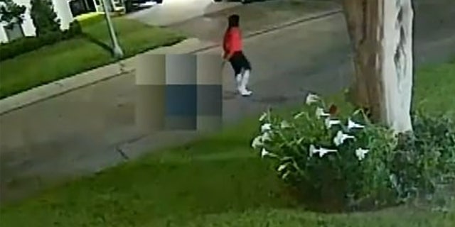 Hannah Landon wearing a red shirt and white boots pulling a cart with a bucket on it.