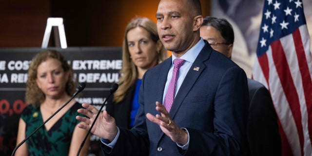 Hakeem Jeffries speaks at a podium with other members of House Democratic leadership standing beside him