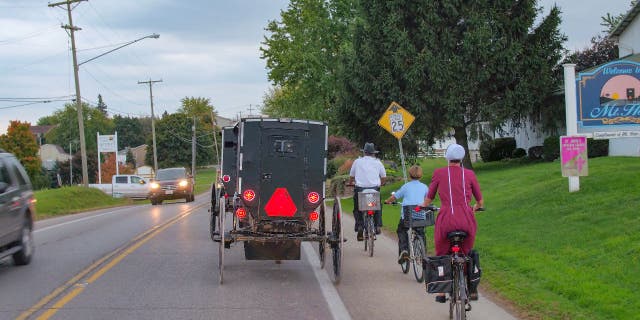 Members of the Amish riding bikes and horse-and-buggies.