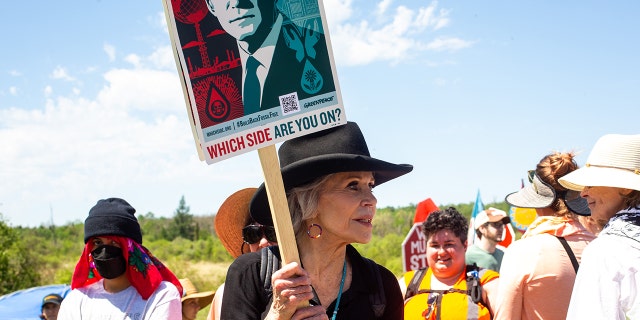 Jane Fonda holding protest sign