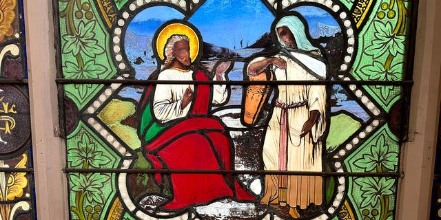 Stained glass depiction of a dark-skinned Jesus with Samaritan woman