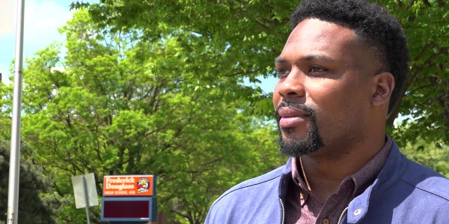 Jovani Patterson stands near Frederick Douglass High School in Baltimore, Maryland