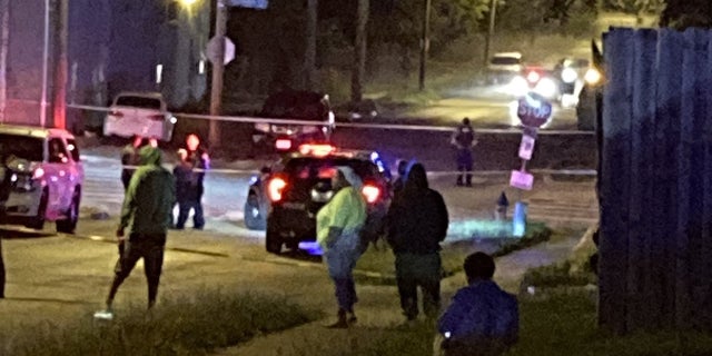 people on street near shooting scene