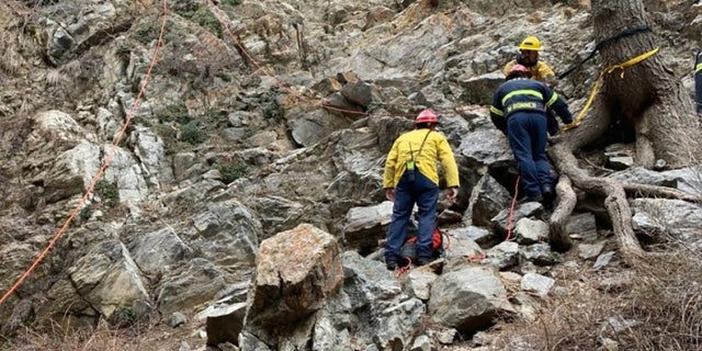 rescue personnel on rocks