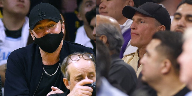 Leonardo DiCaprio sits behind a cameraman in wearing a black baseball hat and face mask watching the Lakers split Woody Harrelson in the crowd wearing a black baseball hat and beige shirt