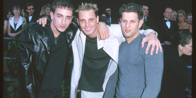 LFO poses for a photo with their arms around each other at an event.