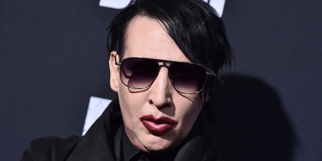 Marilyn Manson wears dark sunglasses and maroon lipstick at red carpet event