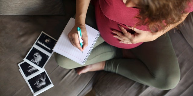 woman writing baby names