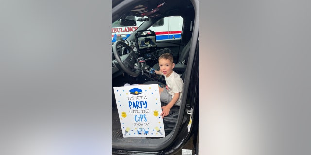little boy in police car