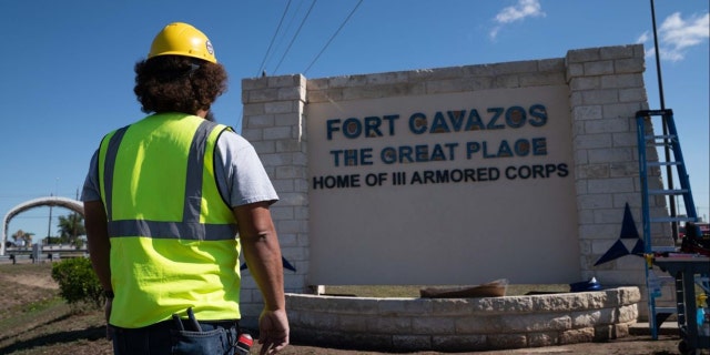 A worker near the entrance sign of the base