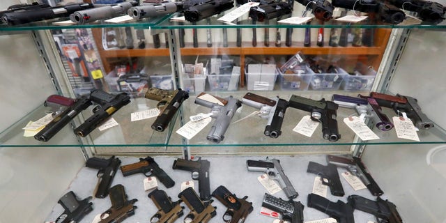 Semi-automatic handguns are on display at a gun store