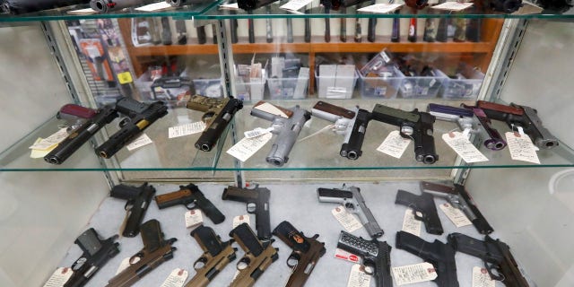 Semi-automatic handguns are on display at a gun store