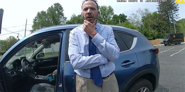 Matthew Reilly is questioned by police officers outside of his vehicle