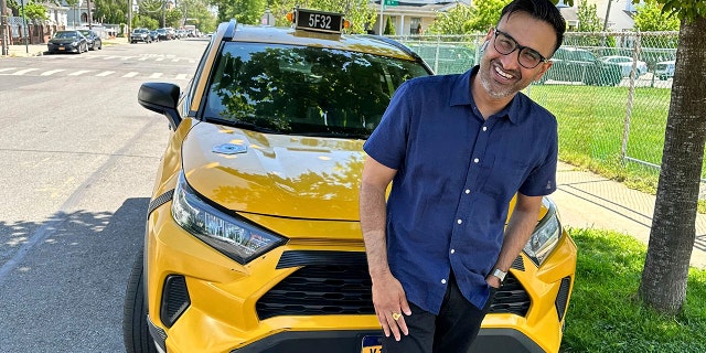 Cab driver Sukhcharn Singh posing in front of his taxi