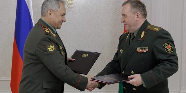 Russian Defence Minister Sergei Shoigu shakes hands with Belarusian Defence Minister Victor Khrenin