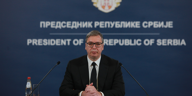 President of Serbia speaking in front of microphones to his nation