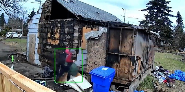 A person walks into a crumbling and burned house in Portland