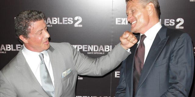 Sylvester Stallone pretends to punch Dolph Lundgren.