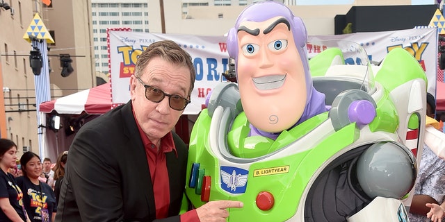 Tim Allen posing with a life size Buzz Lightyear at premiere of Toy Story 4