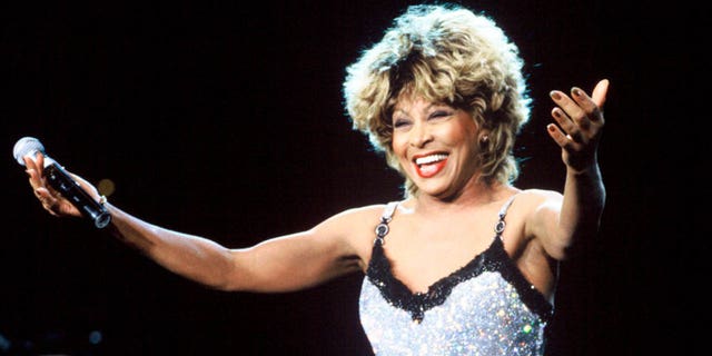 tina turner smiling with arms outstretched on stage
