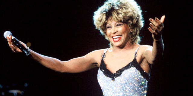 tina turner smiling with arms outstretched on stage