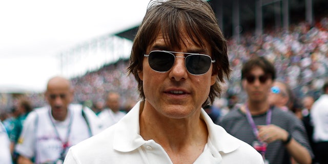 Tom Cruise wears white polo shirt and sunglasses at F1 car race