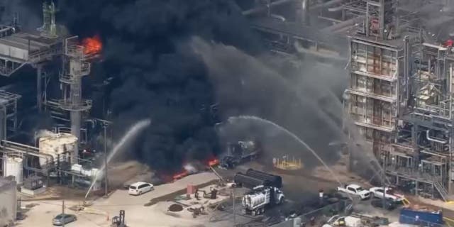 Firefighters throwing water on Deer Park fire