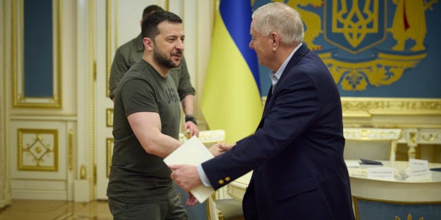 Ukrainian President Volodymyr Zelenskyy shakes hands with Sen. Lindsey Graham