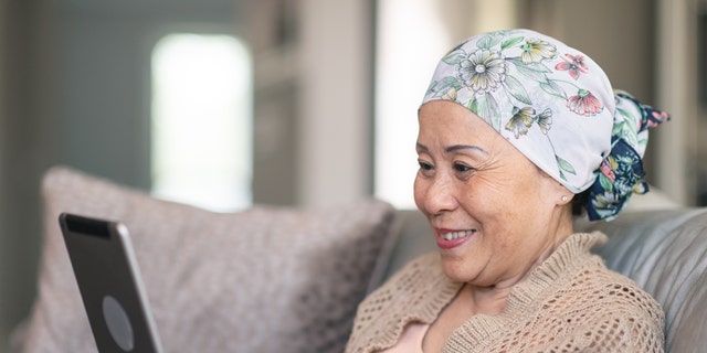 امرأة مصابة بالسرطان على جهاز لوحي