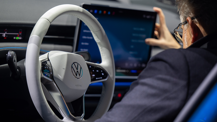 Man sits in a car while using a touchscreen