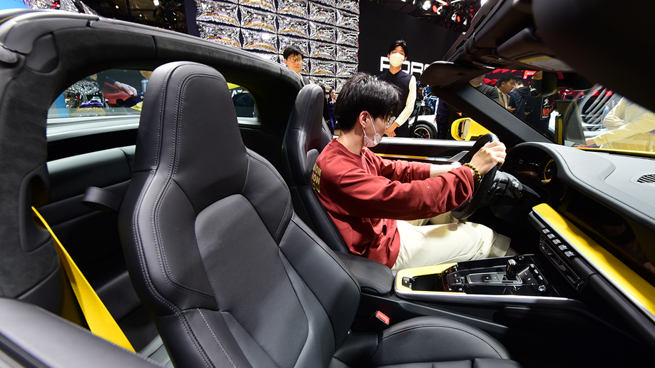 Man sits in a new car in showroom