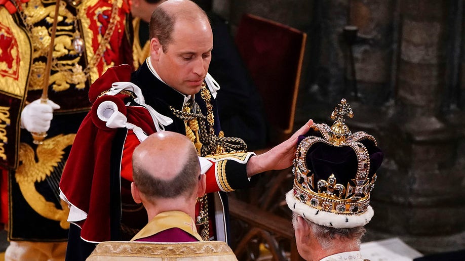 Prince William touches St Edward's Crown on King Charles III's head during his coronation ceremony in Westminster Abbey.