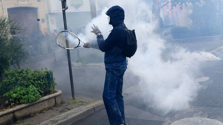 French protester and tear gas canister