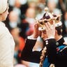 Prince Charles, watched by H.M. Queen Elizabeth II places the gold coronet of The Prince of Wales on his head.