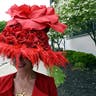 Woman wear a large red hat with roses to the Kentucky Derby.